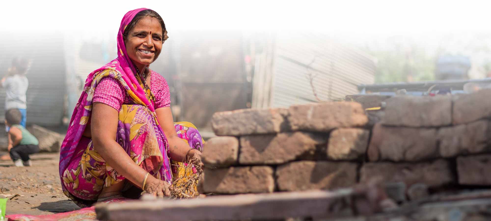Indian woman crouched down looking joyful and content